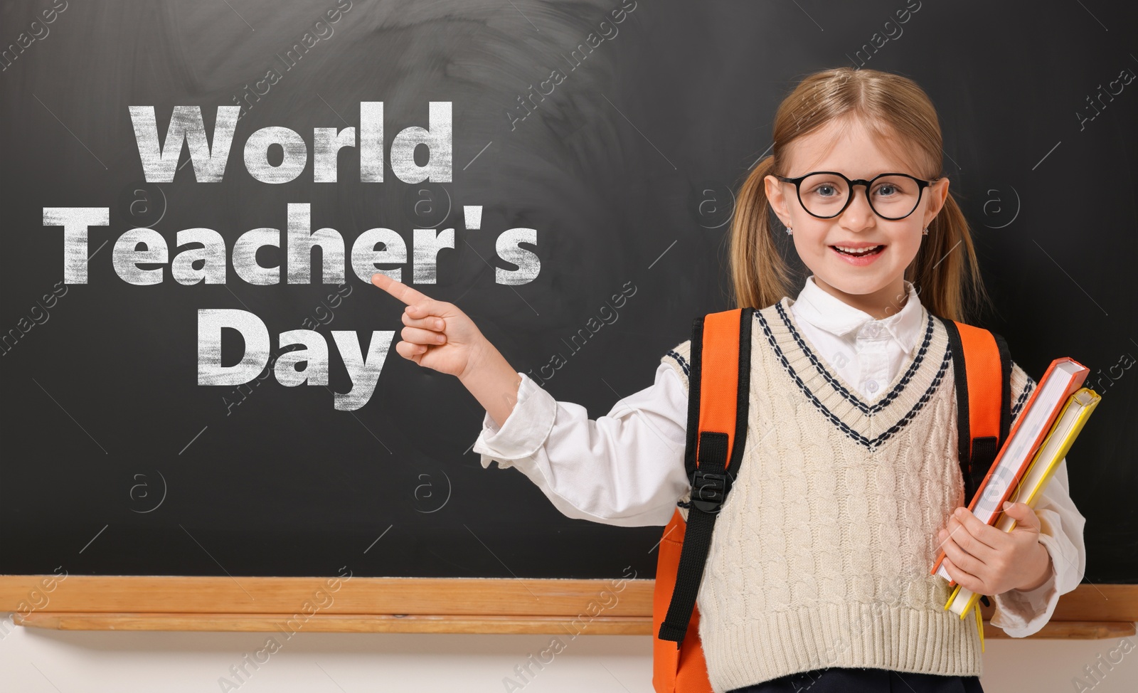Image of Happy Teacher's Day. Cute little girl with eyeglasses near blackboard