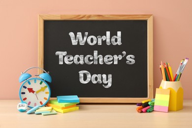 Image of Happy Teacher's Day greeting card with stationery and text on small chalkboard