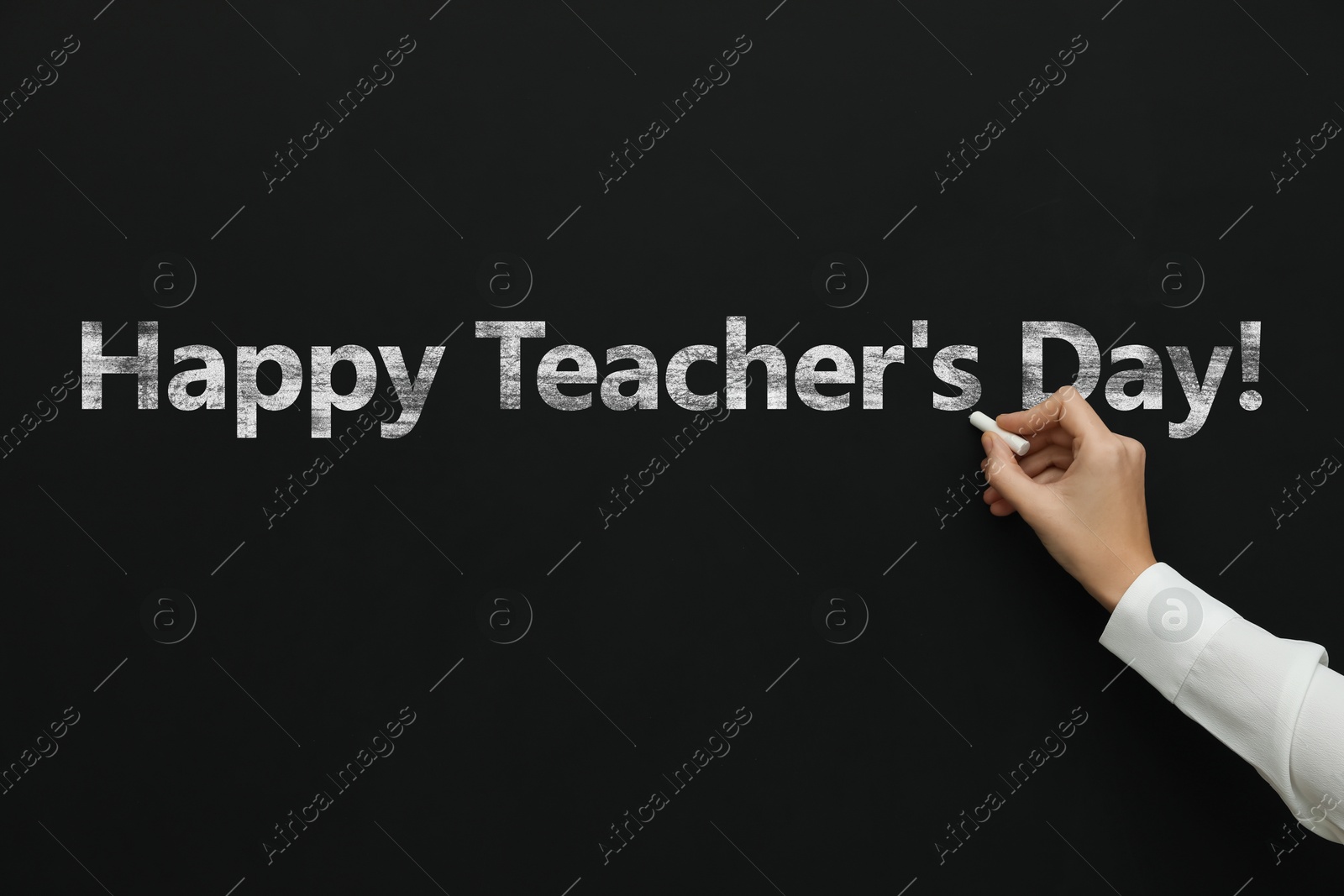 Happy Teacher's Day greeting card. Woman writing text on blackboard, closeup Image of Happy Teacher's Day greeting card. Woman writing text on blackboard, closeup