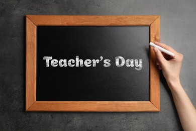Image of Happy Teacher's Day greeting card. Woman writing text on small blackboard, closeup
