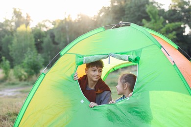 Photo of Brother and sister in camping tent outdoors