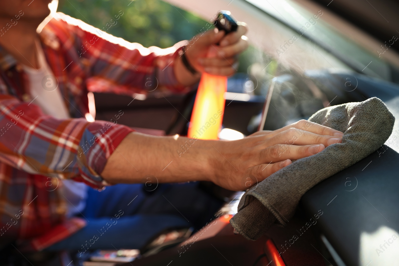 Man wiping car dashboard with grey microfiber rag in salon, closeup Photo of Man wiping car dashboard with grey microfiber rag in salon, closeup