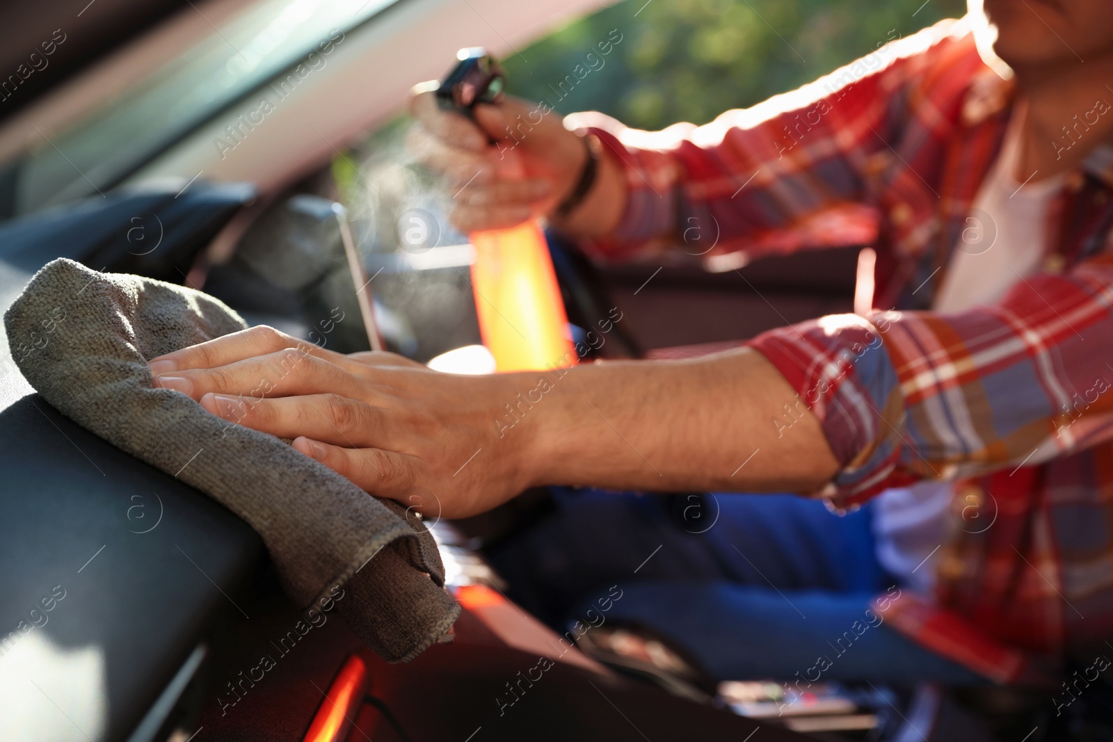 Man wiping car dashboard with grey microfiber rag in salon, closeup Photo of Man wiping car dashboard with grey microfiber rag in salon, closeup