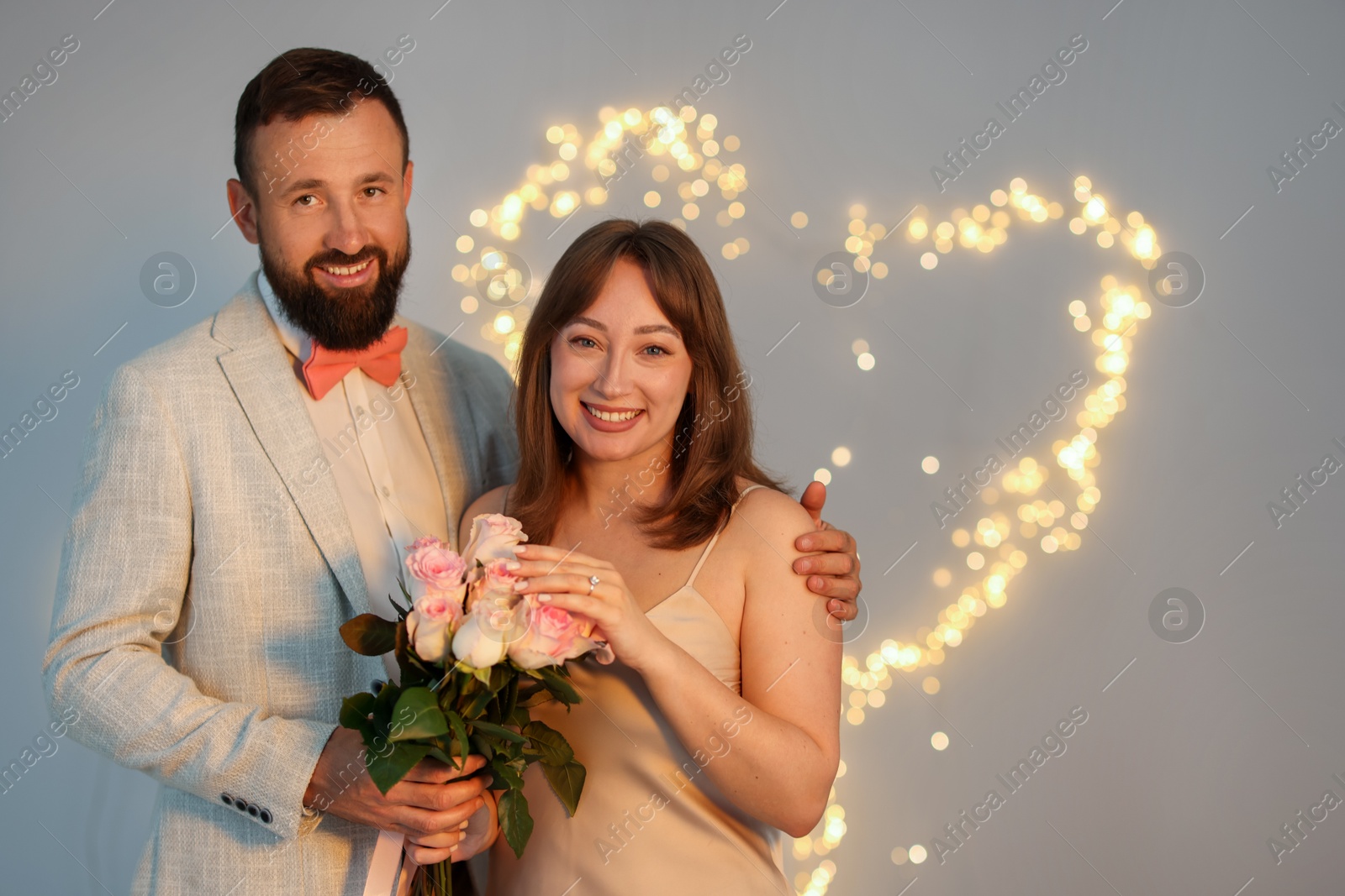 Making marriage proposal. Woman with engagement ring, flowers and her fiance on light grey background, space for text. Bokeh effect Photo of Making marriage proposal. Woman with engagement ring, flowers and her fiance on light grey background, space for text. Bokeh effect
