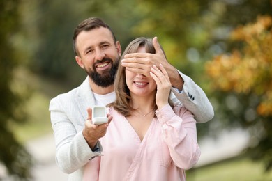Photo of Man with engagement ring making marriage proposal to his girlfriend outdoors