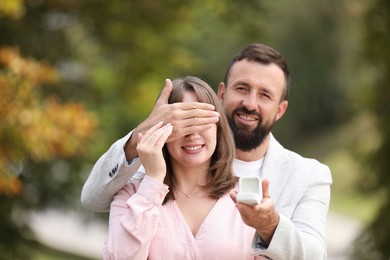 Photo of Man with engagement ring making marriage proposal to his girlfriend outdoors