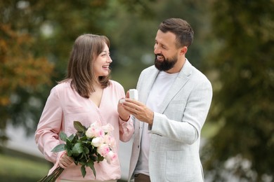 Photo of Man with engagement ring making marriage proposal to his girlfriend outdoors