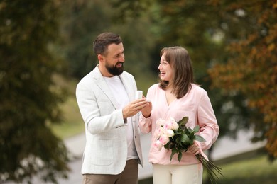 Photo of Man with engagement ring making marriage proposal to his girlfriend outdoors