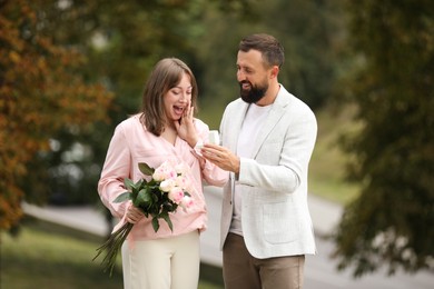 Photo of Man with engagement ring making marriage proposal to his girlfriend outdoors