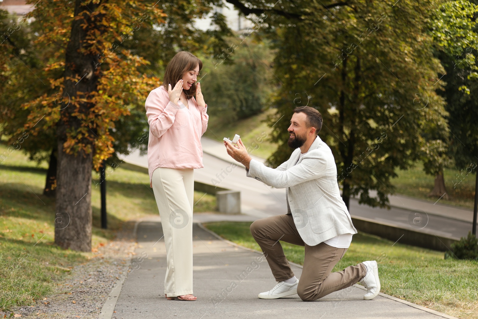 Photo of Man with engagement ring making marriage proposal to his girlfriend outdoors