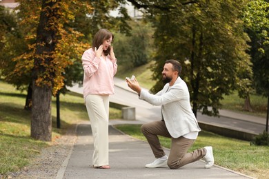 Photo of Man with engagement ring making marriage proposal to his girlfriend outdoors