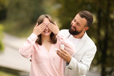 Photo of Man with engagement ring making marriage proposal to his girlfriend outdoors