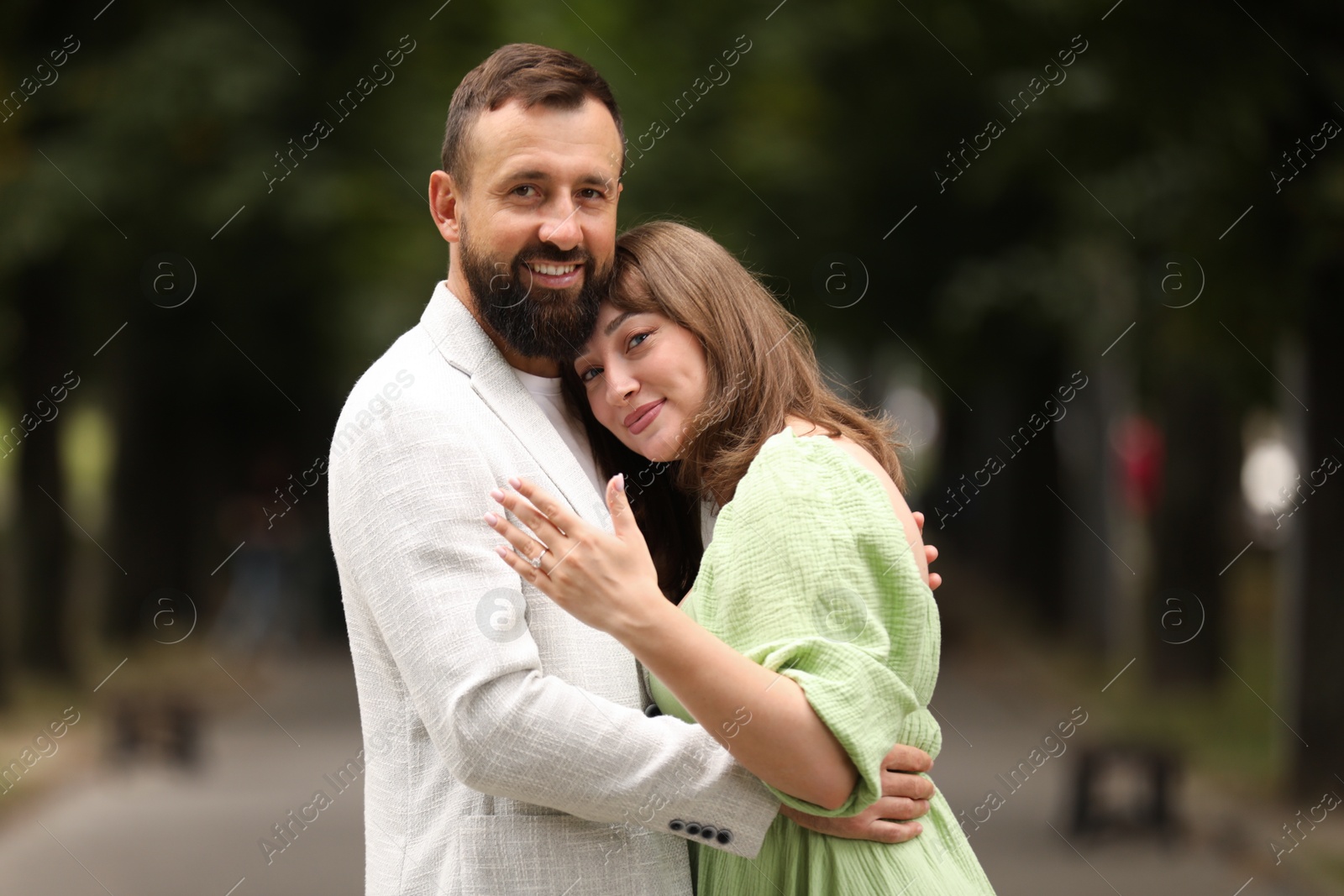 Making marriage proposal. Woman showing engagement ring and hugging her fiance outdoors Photo of Making marriage proposal. Woman showing engagement ring and hugging her fiance outdoors