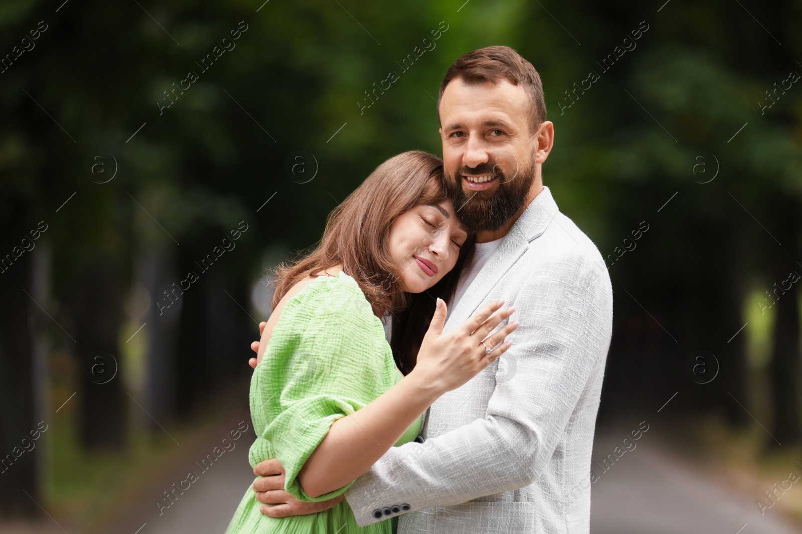 Making marriage proposal. Woman showing engagement ring and hugging her fiance outdoors Photo of Making marriage proposal. Woman showing engagement ring and hugging her fiance outdoors