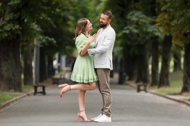 Photo of Making marriage proposal. Woman showing engagement ring and hugging her fiance outdoors