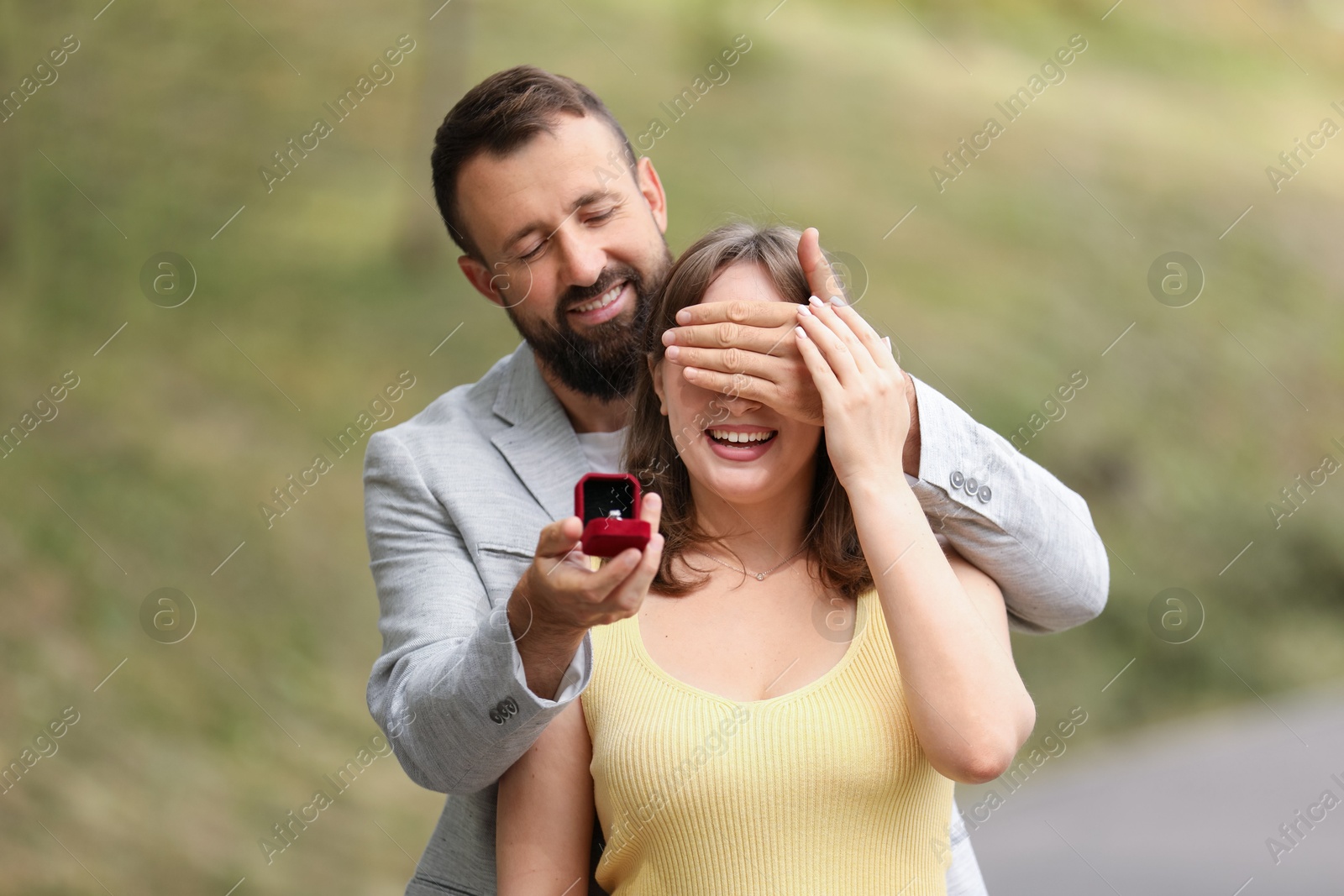 Photo of Man with engagement ring making marriage proposal to his girlfriend outdoors