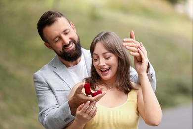 Photo of Man with engagement ring making marriage proposal to his girlfriend outdoors