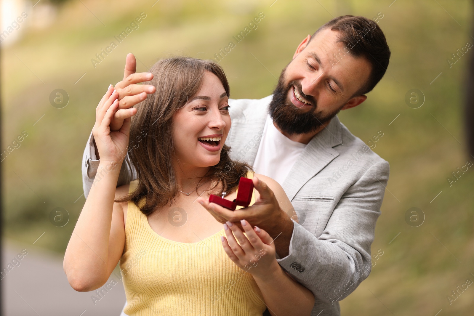 Photo of Man with engagement ring making marriage proposal to his girlfriend outdoors