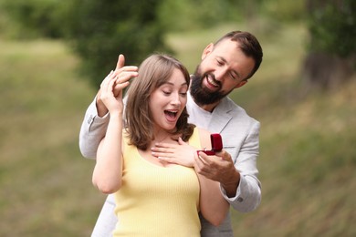 Photo of Man with engagement ring making marriage proposal to his girlfriend outdoors