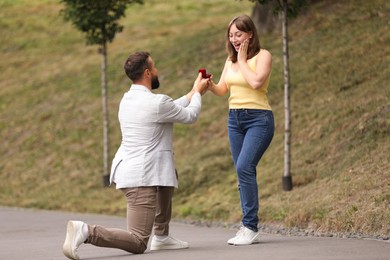 Photo of Man with engagement ring making marriage proposal to his girlfriend outdoors