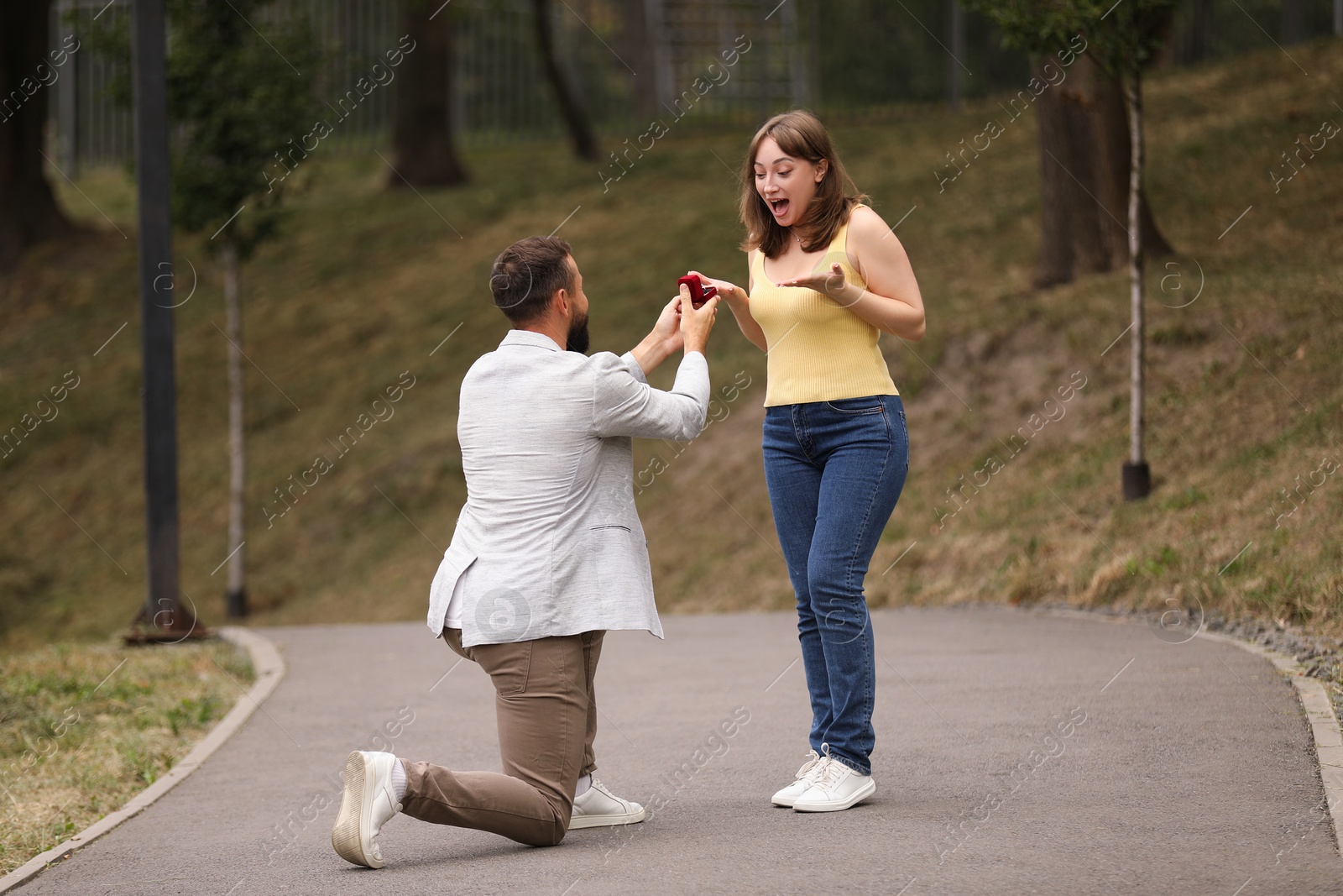 Photo of Man with engagement ring making marriage proposal to his girlfriend outdoors