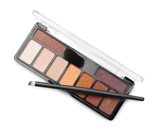 Photo of Beautiful eyeshadow palette with brush isolated on white, top view