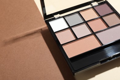 Photo of Beautiful eyeshadow palette on color background, closeup. Space for text