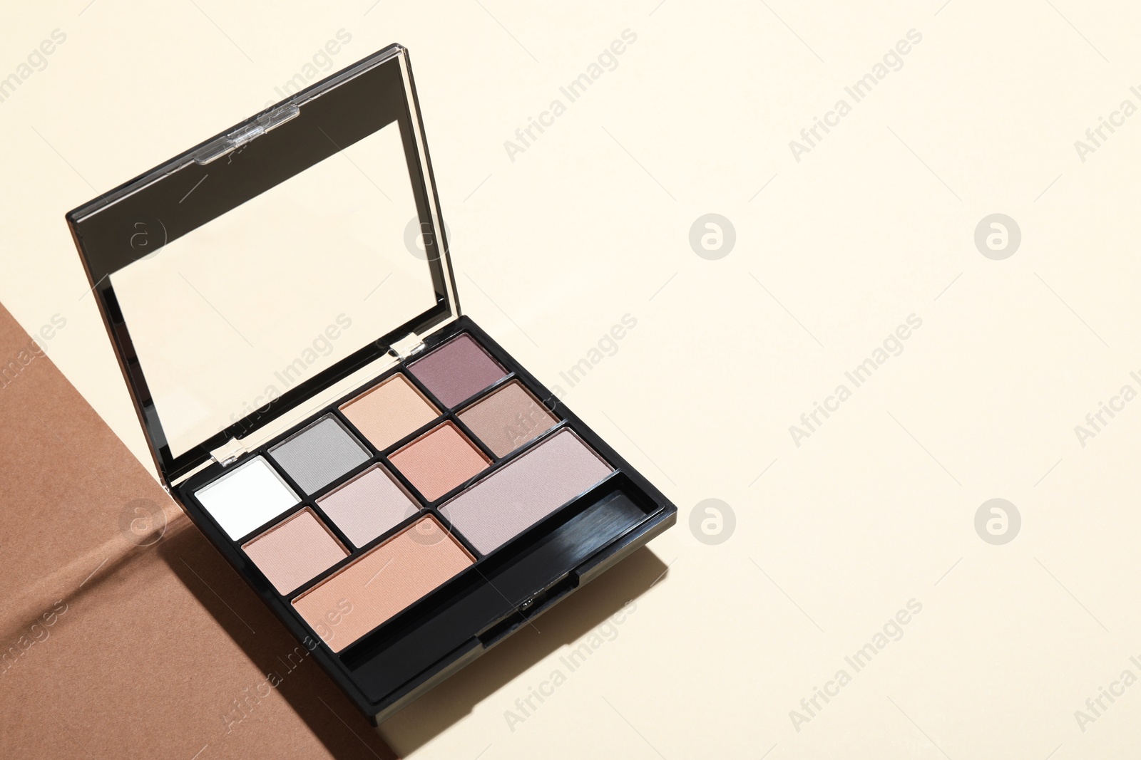 Photo of Beautiful eyeshadow palette on color background. Space for text