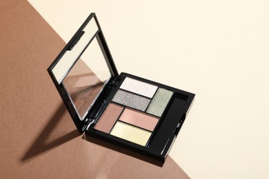 Photo of Beautiful eyeshadow palette on color background. Space for text