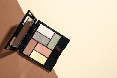 Photo of Beautiful eyeshadow palette on color background, top view. Space for text