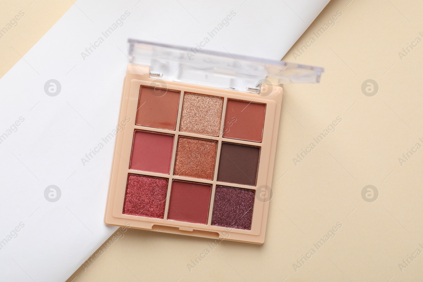 Photo of Beautiful eyeshadow palette on beige background, top view
