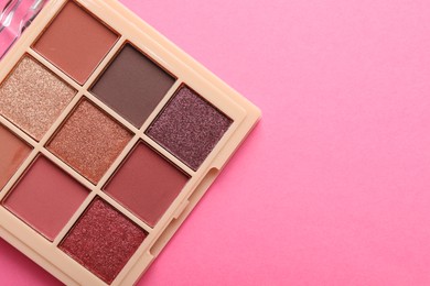 Photo of Beautiful eyeshadow palette on pink background, top view. Space for text