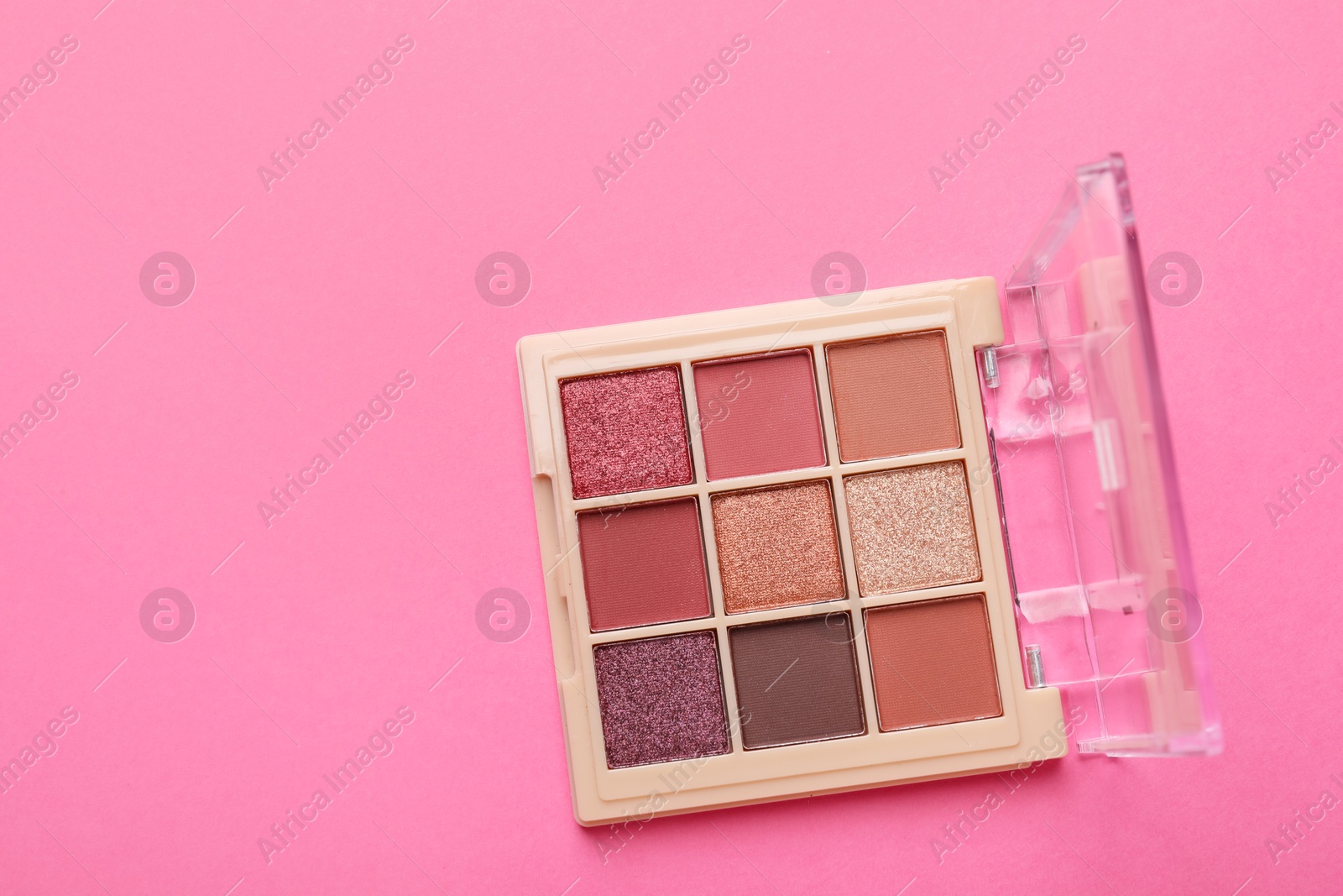 Photo of Beautiful eyeshadow palette on pink background, top view. Space for text