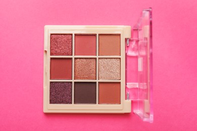 Photo of Beautiful eyeshadow palette on pink background, top view
