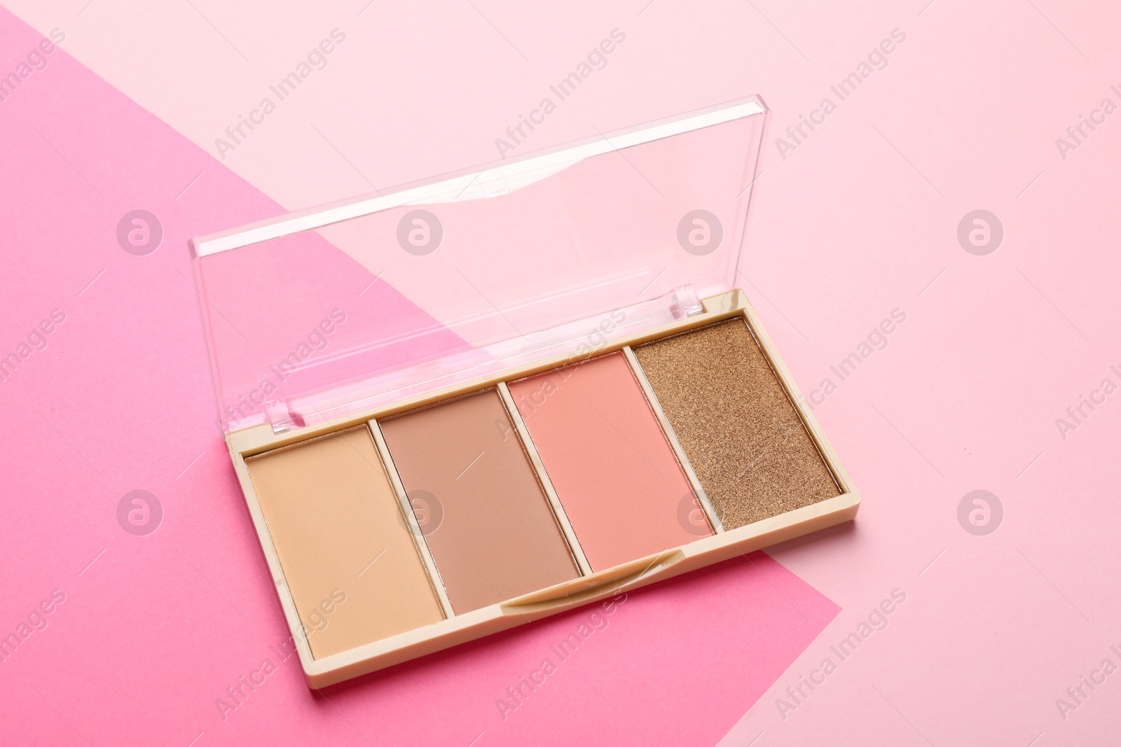 Photo of Beautiful contouring palette with blush and bronzer on pink background