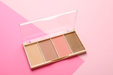 Photo of Beautiful contouring palette with blush and bronzer on pink background