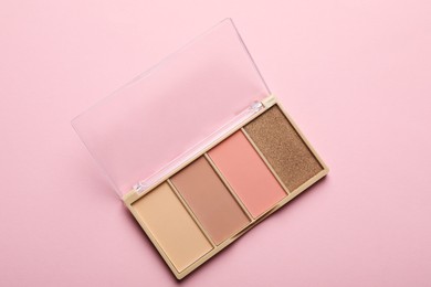 Photo of Beautiful contouring palette on light pink background, top view