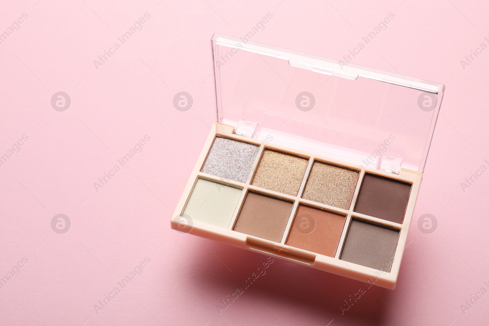 Photo of Beautiful eyeshadow palette on light pink background