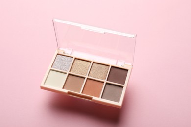 Photo of Beautiful eyeshadow palette on light pink background