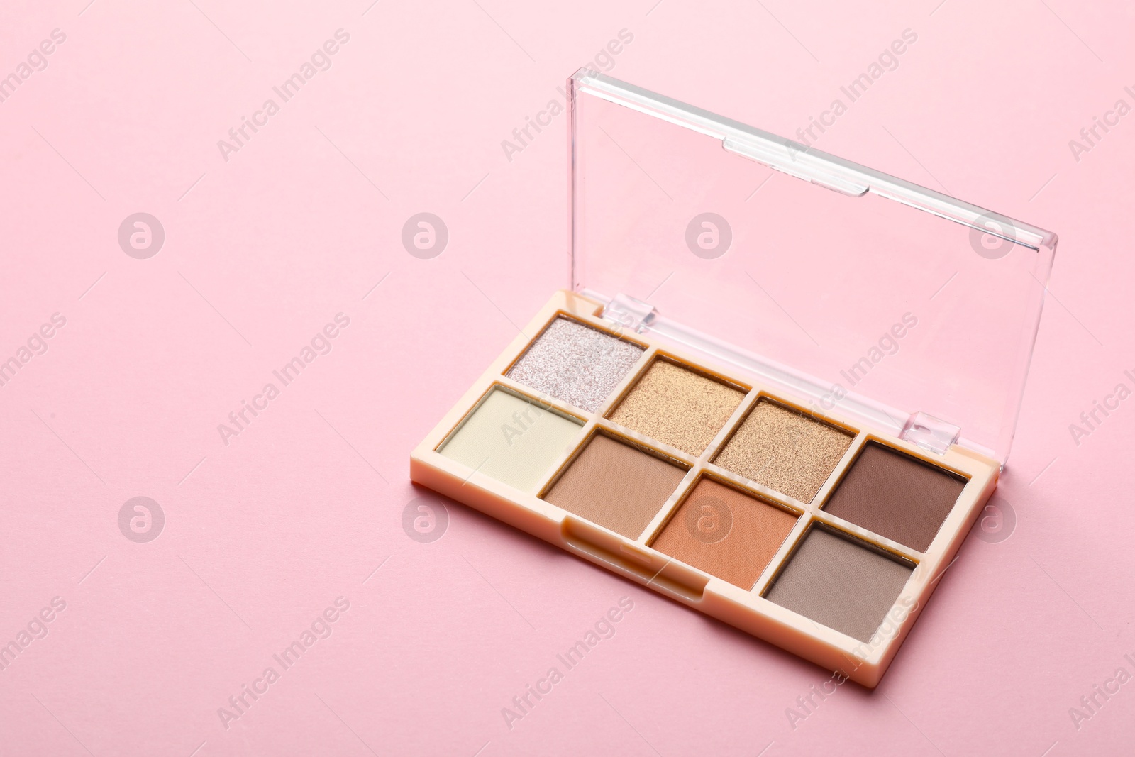 Photo of Beautiful eyeshadow palette on light pink background. Space for text