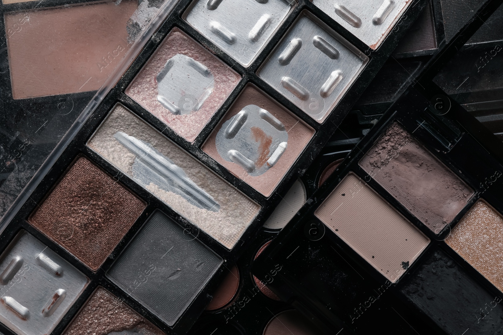 Photo of Different used eyeshadow palettes as background, closeup