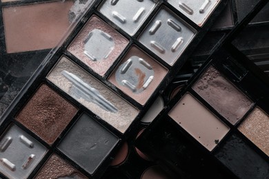Photo of Different used eyeshadow palettes as background, closeup