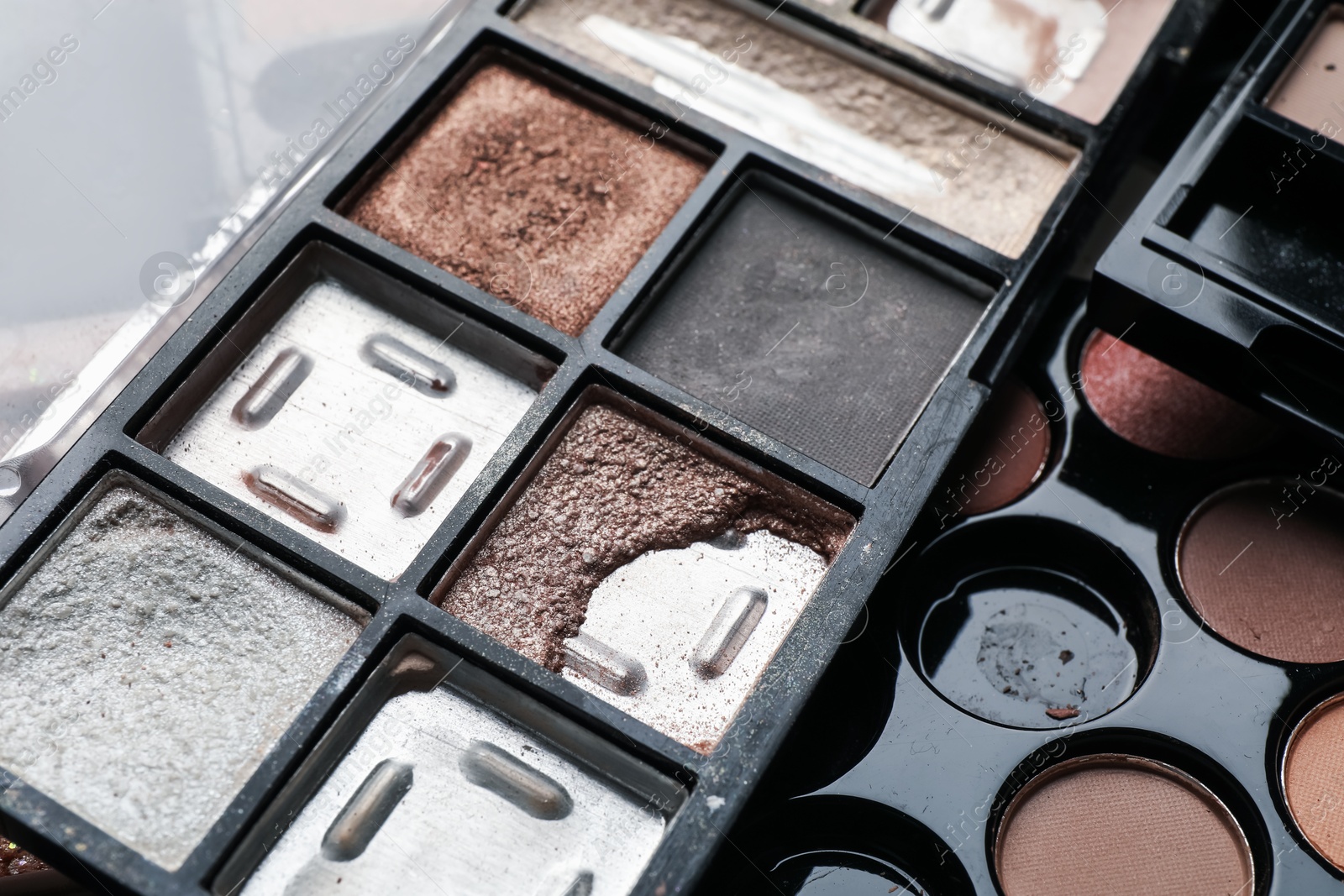 Photo of Different used eyeshadow palettes as background, closeup