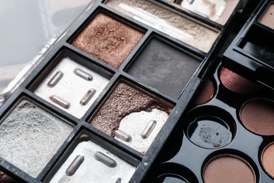 Photo of Different used eyeshadow palettes as background, closeup