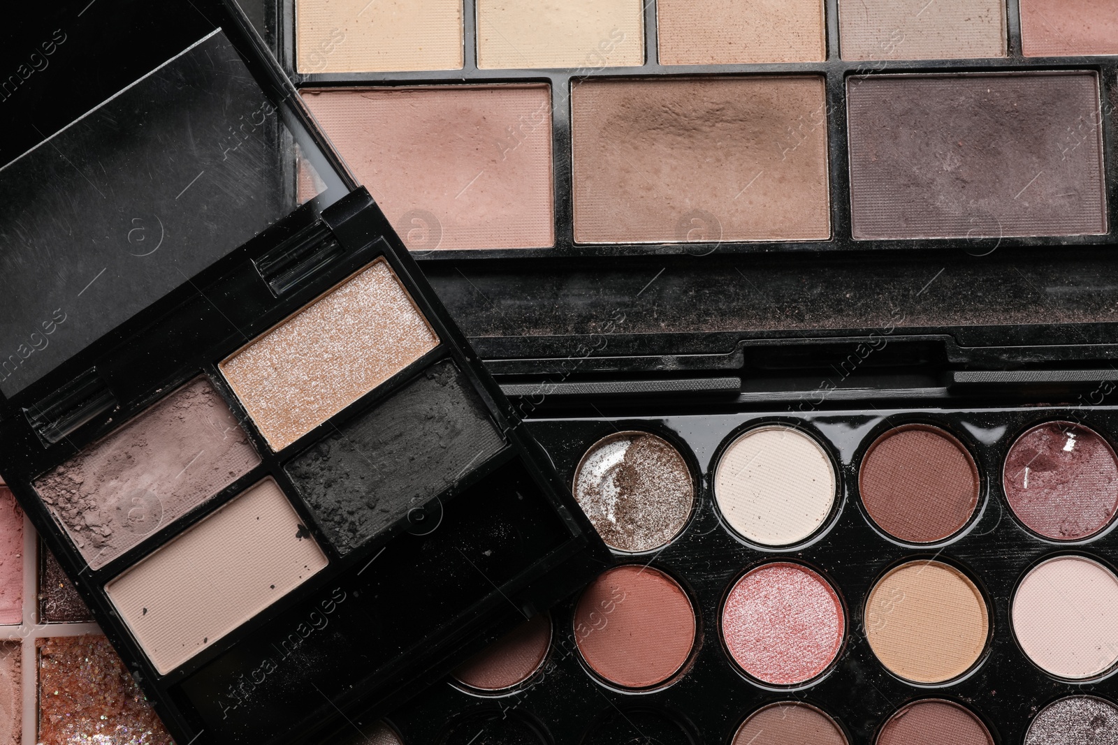 Photo of Different used eyeshadow palettes as background, closeup