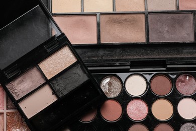 Photo of Different used eyeshadow palettes as background, closeup