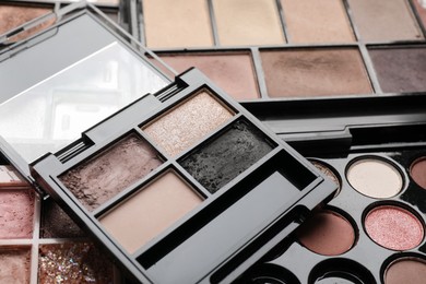Photo of Different used eyeshadow palettes as background, closeup