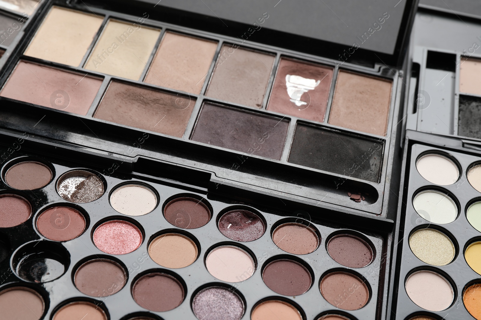 Photo of Different used eyeshadow palettes as background, closeup