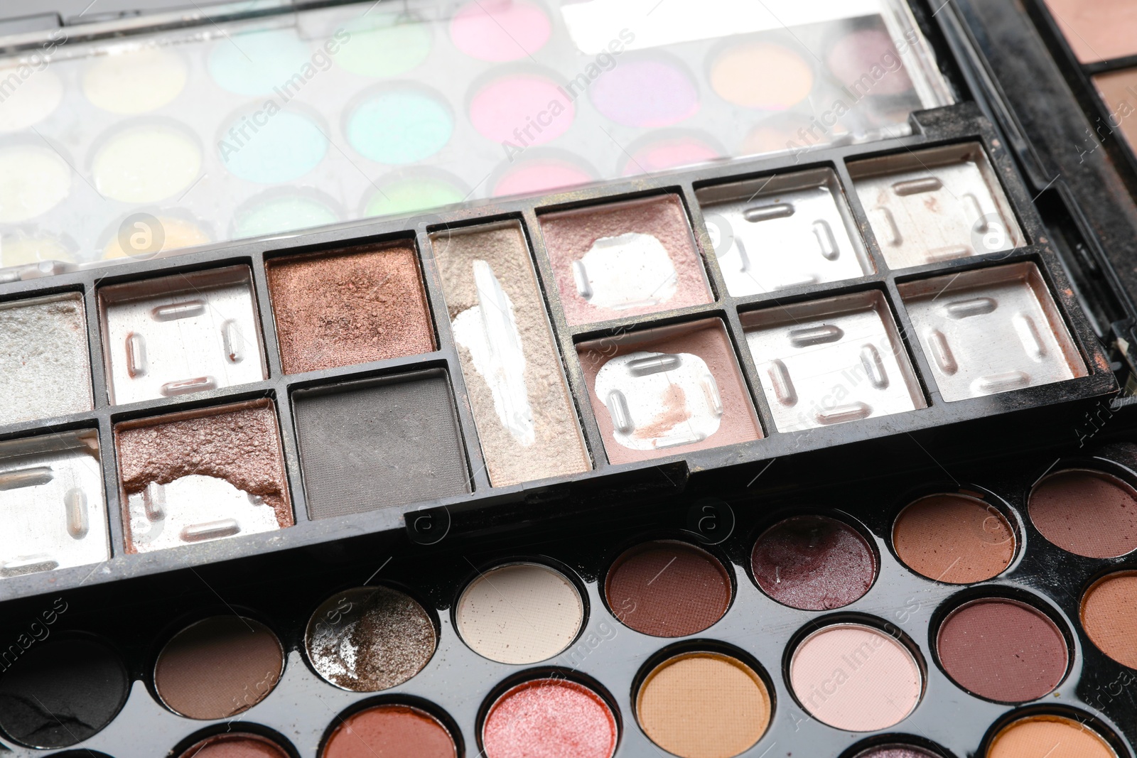 Photo of Different used eyeshadow palettes as background, closeup