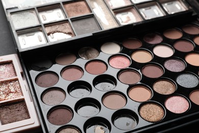 Photo of Different used eyeshadow palettes as background, closeup